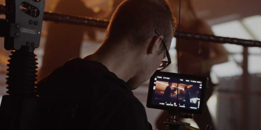 a man filming a video of 2 people boxing